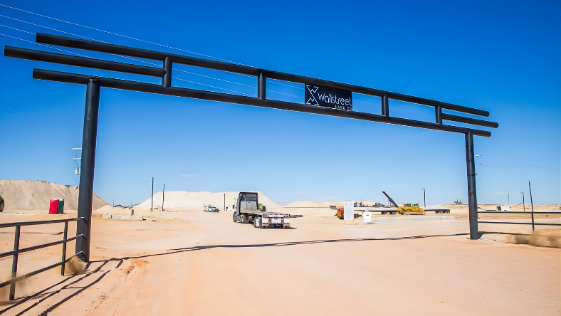 Entrance to a frac sand facility in West Texas with trucks and loading infrastructure