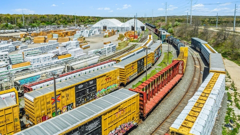 Freight railcars loaded with sand materials at an industrial rail yard